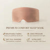 A blush pink sleep mask centered on a light beige background with descriptive text below reading 'PREMIUM COMFORT SLEEP MASK' and feature callouts for breathable fabric, zero pressure, 360° full shading, and ultra-soft comfort.